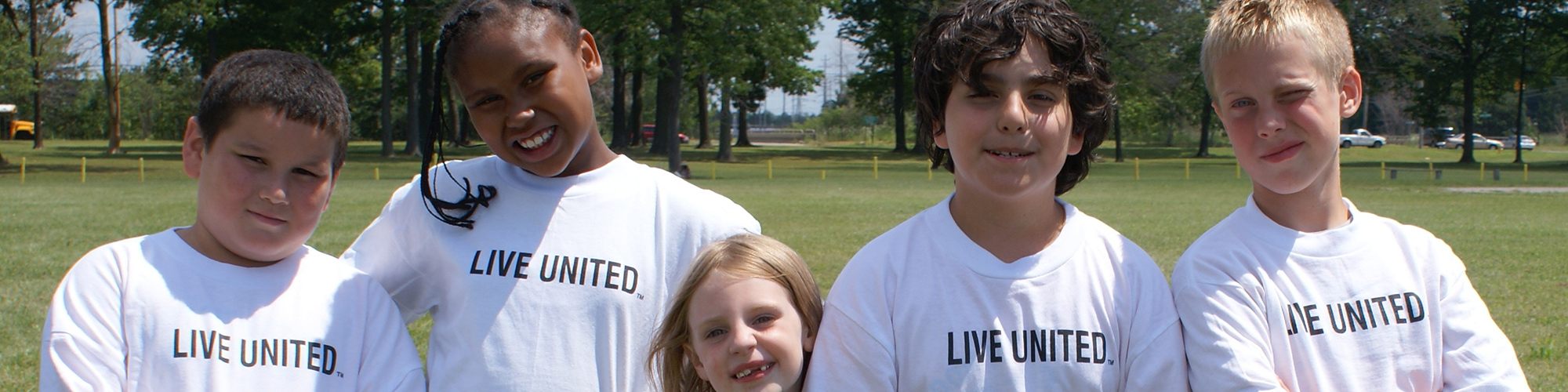 Five children wearing white Live United tshirts