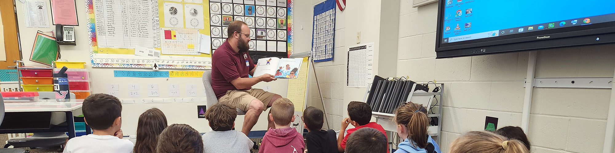 A volunteer reader reading to elementary school students