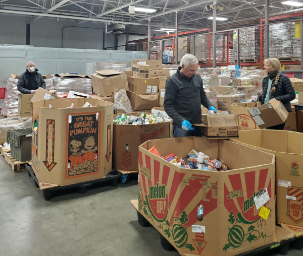 Volunteers sort food at the Food Center warehouse
