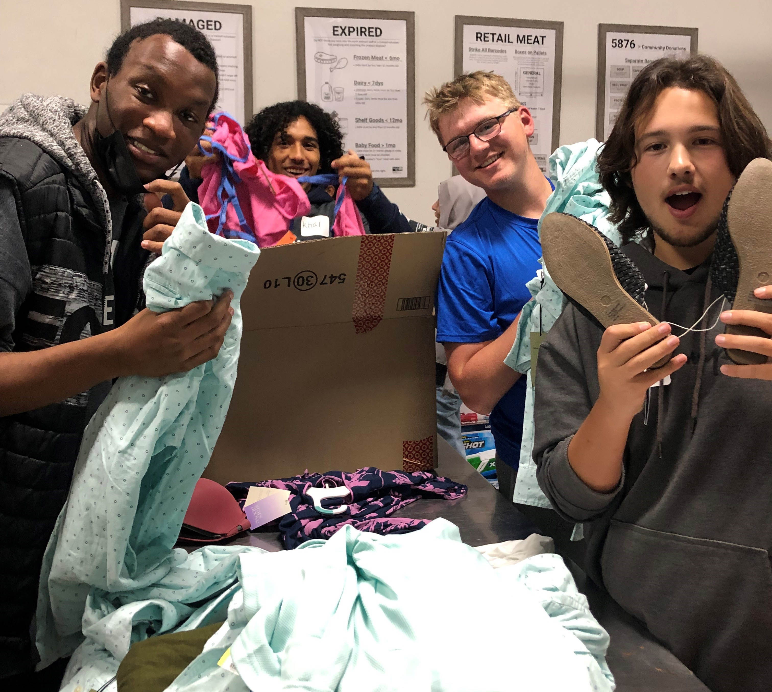 Four Student United Way participants volunteer at the Food Center sorting donated clothing