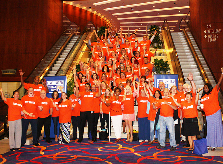A large group of United Way volunteers standing and lining up stairs in celebration