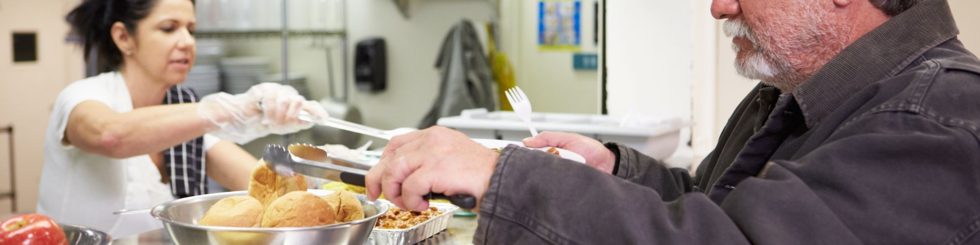 A man being served a meal at a community meal site