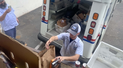 Letter carrier dropping off food donations to the Food Center